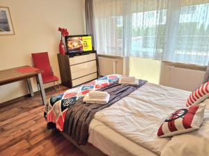1 dormitorio con cama, mesa y TV en Apartament TRZY POMOSTY Villa Mistral en Świnoujście