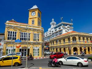 Phuket Panwa Beachfront Resort في شاطئ بنوا: شارع المدينة فيه برج وساعات ومباني