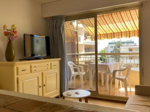 - un salon avec une télévision et une table avec des chaises dans l'établissement Apartment Genius Superior Ste Maxime 307, à Sainte-Maxime