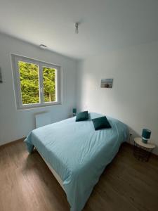 - une chambre blanche avec un grand lit et une fenêtre dans l'établissement Maison sur la colline, à Saint-Martin-lʼHortier