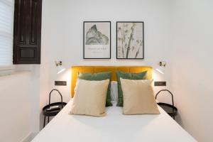 a bedroom with a white bed with two pillows at Granadi Apartamentos in Granada