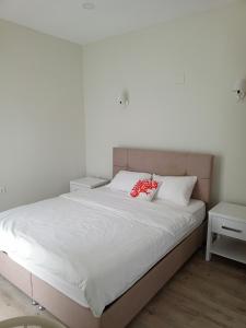 a bed with white sheets and red pillows on it at Port Hotel, Tasucu in Silifke