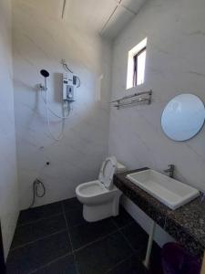 a bathroom with a sink and a toilet and a mirror at Cempaka Beach Resort in Kuantan