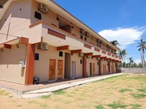 a building with many doors and windows and a field at Cempaka Beach Resort in Kuantan
