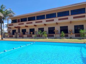 ein Gebäude mit einem Pool vor einem Gebäude in der Unterkunft Cempaka Beach Resort in Kuantan