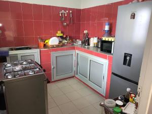 a small kitchen with red tiles on the walls at Chez saly in Saint-Louis