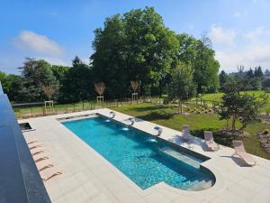 a large swimming pool with chairs and a yard at Domaine de Dolomieu Hotel & Spa - BW Premier Collection in Dolomieux