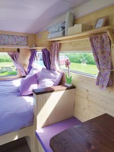 - une chambre dans un salon avec un lit et une fenêtre dans l'établissement Camping Les Ronds Duval face aux îles anglo-normandes, à Les Moitiers-dʼAllonne