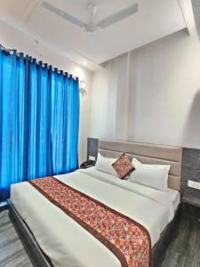 um quarto com uma cama grande e cortinas azuis em Hotel The Restu And Restaurant 300 Meter From Golden Temple em Amritsar