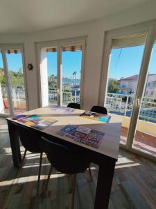 una mesa con sillas en una habitación con ventanas en Sanary Port et Plages Climatisé, en Six-Fours-les-Plages 4 fotos más