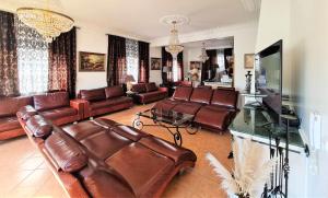 a living room with leather couches and a television at Silver Village Residence in Maceira