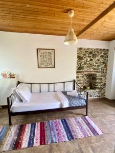 a bedroom with a bed and a stone wall at Gattilusi View Cottage in Samothraki