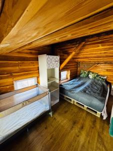 シュチトナにあるLoft Szczytnaのログキャビン内のベッド2台が備わる部屋です。