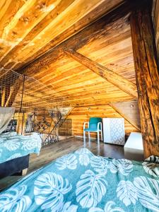 1 Schlafzimmer mit 2 Betten und Holzdecke in der Unterkunft Loft Szczytna in Szczytna