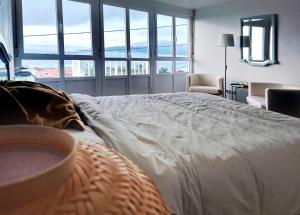 a large white bed in a room with large windows at Miradoiro 38 in Lira