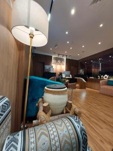 فندق إيه جي في أبوظبي: غرفة معيشة مع مصباح أرضي وأريكة