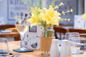 een tafel met een glas wijn en een vaas met bloemen bij Kings Arms Hotel in Abergavenny