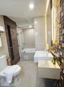 La salle de bains est pourvue de toilettes, d'un lavabo et d'une baignoire. dans l'établissement Aspira Suites Sukhumvit 20, à Bangkok