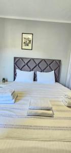 een slaapkamer met een groot bed met witte lakens bij Apartments Popovic in Kotor