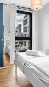 ein Schlafzimmer mit einem Bett und einem großen Fenster in der Unterkunft Family Apartments Portova in Gdynia