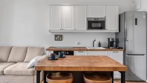 eine Küche mit einem Holztisch und einem Kühlschrank in der Unterkunft Family Apartments Portova in Gdynia