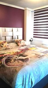 ein Schlafzimmer mit einem großen Bett mit Design darauf in der Unterkunft Las MARIPOSAS , 3 habitaciones in El Astillero