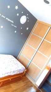ein Schlafzimmer mit einem Bett und einer Wand mit Mond und Sternen in der Unterkunft Las MARIPOSAS , 3 habitaciones in El Astillero