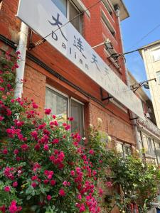 a sign for a restaurant with flowers in front of a building at 大连天天国际青年旅社 in Dalian