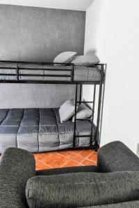 a room with two bunk beds with pillows and a couch at Nomad Casa en la mejor ubicación in Hermosillo
