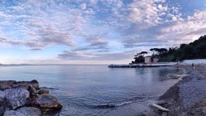 a beach with a cloudy sky and the water at Il Loft nel Borgo in Ameglia