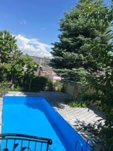 una piscina azul en un patio con árboles en LARGE 5 BEDROOM LUXURY VILLA, en Ereván