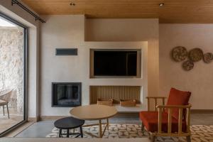 a living room with a table and chairs and a tv at Radisson Blu Hotel, Kas in Kaş