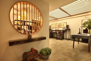 uma sala de estar com um espelho e um piano em The Beyond Villa Guilin em Guilin