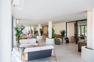 a living room with white furniture and plants at Pacha Hotel in Ibiza Town