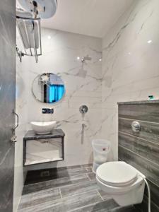 uma casa de banho com um WC, um lavatório e um espelho. em Hotel The Restu And Restaurant 300 Meter From Golden Temple em Amritsar