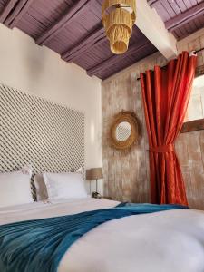 een slaapkamer met een bed en een rood gordijn bij Dar Adul in Essaouira