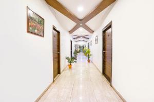 a corridor of a house with white walls and wooden ceilings at FabHotel Ratna Palace in Ahmedabad