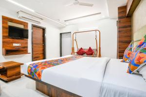 a bedroom with a bed and a tv at FabHotel Ratna Palace in Ahmedabad