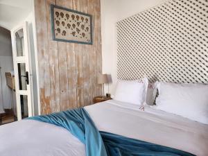 a bedroom with a white bed with a wooden headboard at Dar Adul in Essaouira