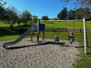 two children playing on a swing set at a park at Landgasthof Waldeck in Stadtprozelten