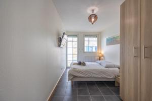 a bedroom with a bed and a window at La Tanière des Oursons - proche de la plage in Courseulles-sur-Mer