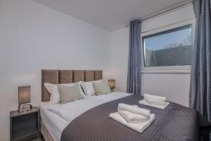 a bedroom with a large bed with two white towels on it at Premium Apartments Mellea in Vantačići
