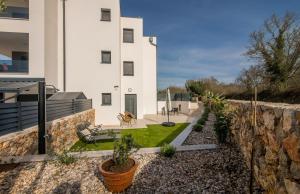 a building with a retaining wall and a yard with plants at Premium Apartments Mellea in Vantačići