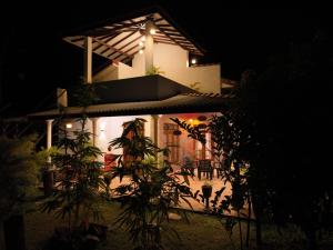 une maison éclairée la nuit avec une installation dans l'établissement Nature World Jungle Paradise, à Uda Walawe