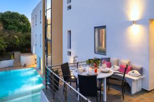 a balcony with a table and a swimming pool at Themis Private Villa, Swimming Pool & Jacuzzi in Ialyssos