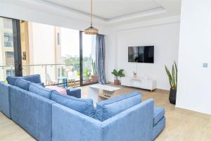 - un salon avec deux canapés bleus et une télévision dans l'établissement Velasani, à Nairobi
