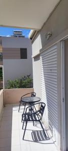 una mesa y sillas en el balcón de una casa en Top Holidays Apartments, en La Canea