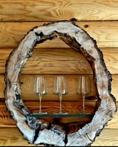 two wine glasses on a wooden wall at Wayside Cottage in Batumi