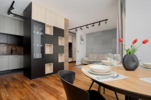 eine Küche und ein Esszimmer mit einem Tisch und Stühlen in der Unterkunft Cozy Apartments with Parking in the 19th District by Renters in Warschau