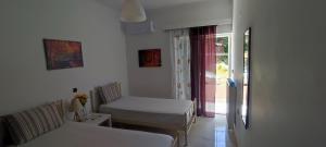 a room with a bed and a chair and a window at Top Holidays Apartments in Chania
